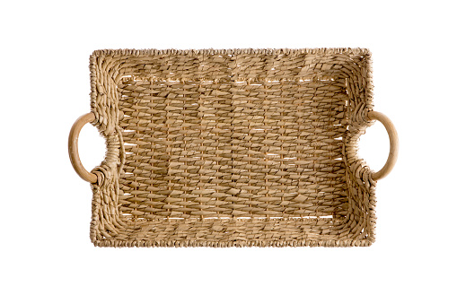 Overhead view of a rectangular wicker tray made of interwoven willow canes showing the texture of the weave with curved wooden handles, isolated on white