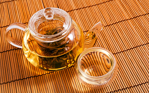 Green tea Jasmine Pearls(Mo Li Long Zhu) in the glass teapot and a glass cup