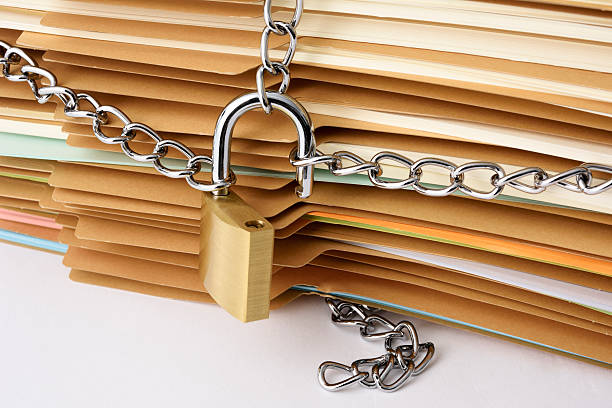 istock Close-up of stacked brown file folder with unlocked padlock 598954178