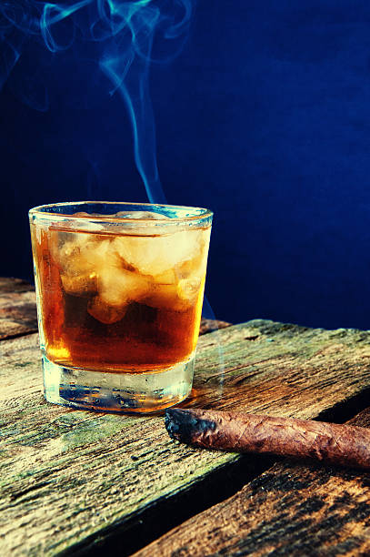 istock Cigar and whiskey on the old wooden background 598956800