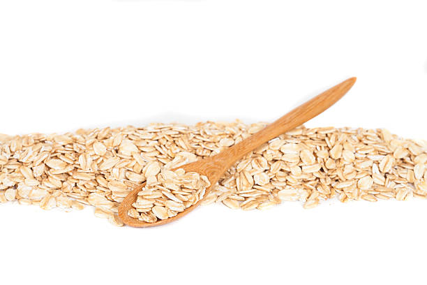 istock Oats flakes pile in wood spoon on white background 598956932