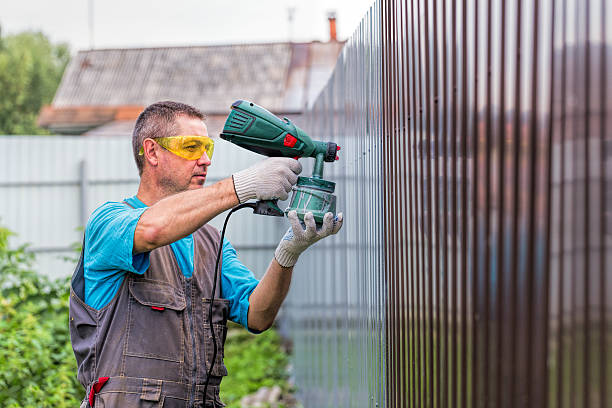 istock Positive man in overalls with spray gun in hand 598958310