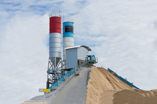 Cement production in quarry isolated on cloudy background