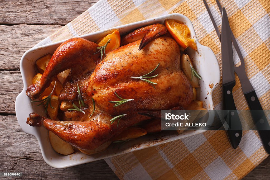 baked chicken with apples in the baking dish closeup. horizontal baked chicken with apples in the baking dish on a table close-up. Horizontal top view Chicken Meat Stock Photo