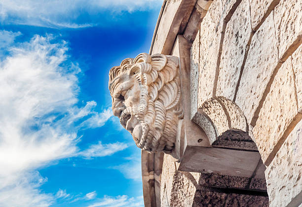 istock Historic building detail man head with blue cloudy sky 599100520
