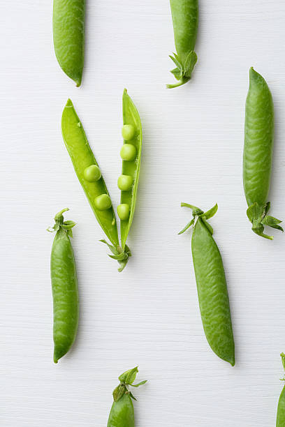 istock Green peas on white wood 599102258