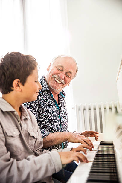 istock Little boy playing piano with his grandfather 599102622