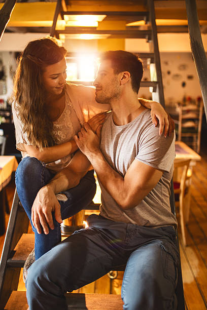 istock Young couple in love on staircase looking at each other. 599102716