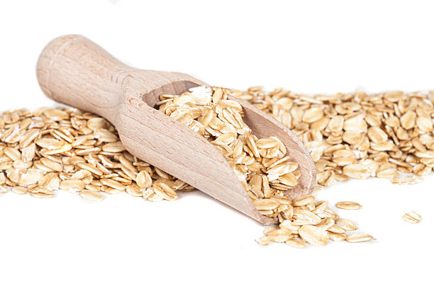 istock Oats flakes pile in wood spoon on white background 599102894