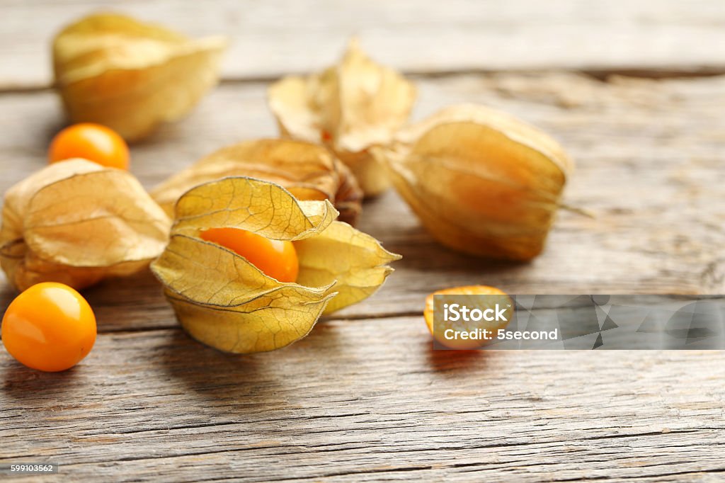 Ripe physalis on a grey wooden table Berry Fruit Stock Photo