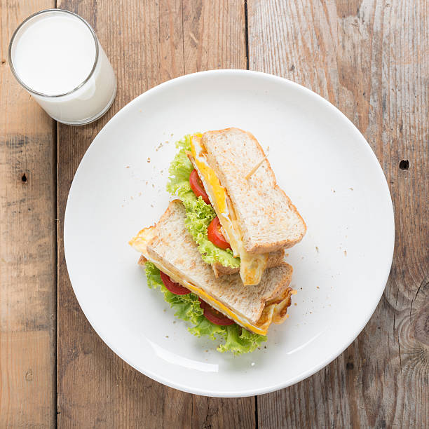 сэндвичи жареное яйцо с сыром и молоком на деревянном столе. - oregano freshness herb brown стоковые фото и изображения