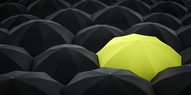 istock Unique yellow umbrella among many dark ones. 599106076