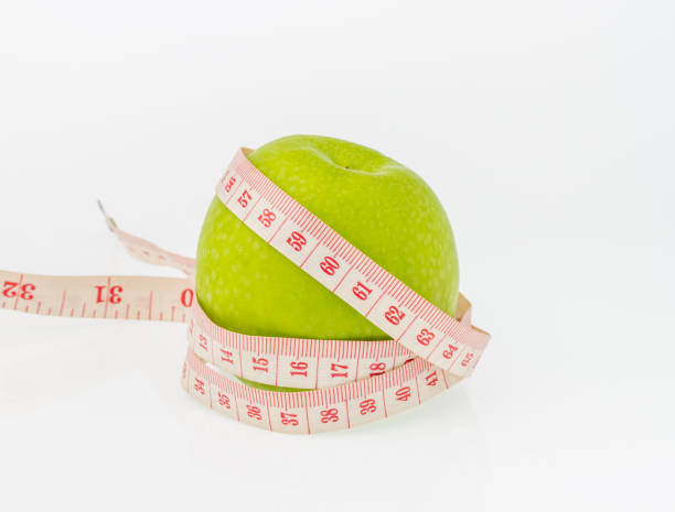 istock green apple and  measuring tape on white background. 599109172