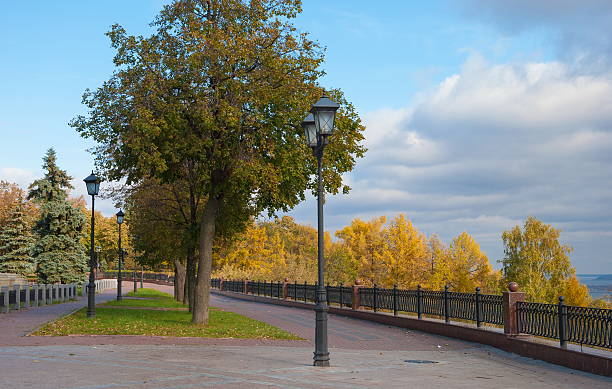 Autumn promenade in the city with a fence and lanterns