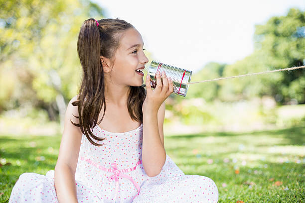 istock Young girl speaking through tin can phone 599112174