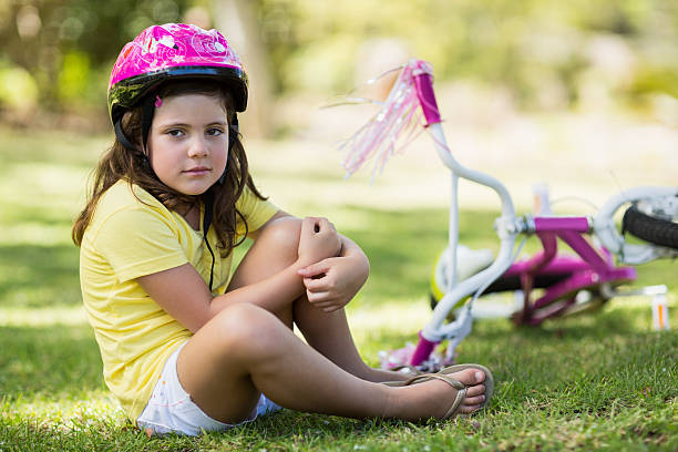 istock Young girl getting injured after falling from bicycle 599112258