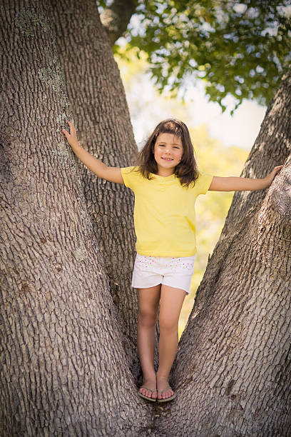 istock Young girl standing on tree trunk 599112274