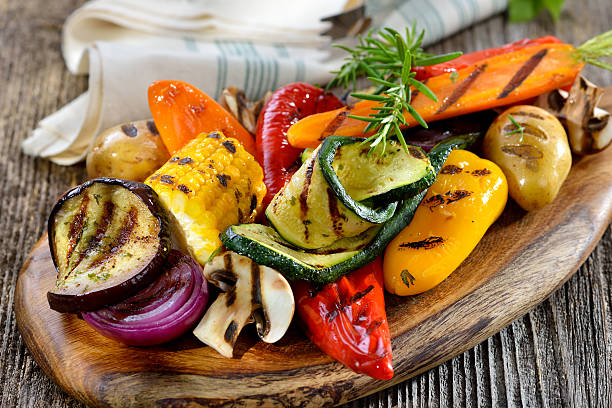 Grilled vegetables Vegan cuisine: Grilled mixed vegetables on a wooden cutting board roasted stock pictures, royalty-free photos & images