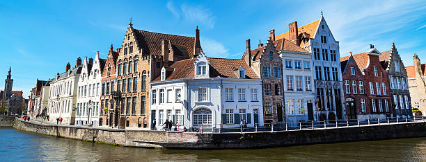 panorama com canal e colorido casas tradicionais em brugge, belgium - bruges belgium history scenics - fotografias e filmes do acervo