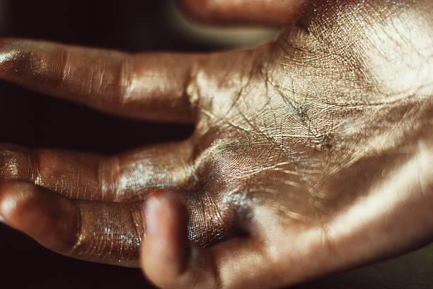 menschliche hand mit goldstaub verziert - körperbemalung stock-fotos und bilder