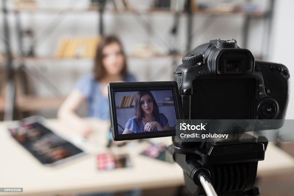 Young female beauty blogger on camera screen Young female beauty blogger on camera screen. Beautiful girl recording video at studio. Fashion, makeup, technology concept Home Video Camera Stock Photo