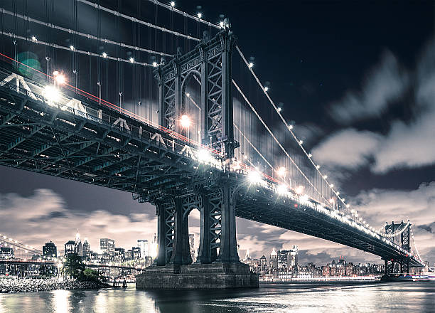 nyc skyline und manhattan-brücke - new york city brooklyn bridge night stock-fotos und bilder