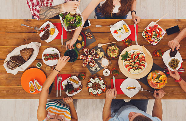 istock People eat healthy meals at festive table dinner party 599123080