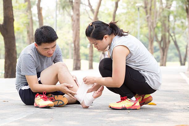 infortunio sportivo. uomo con ginocchio slogato contorto - human knee physical injury bandage muscular build foto e immagini stock