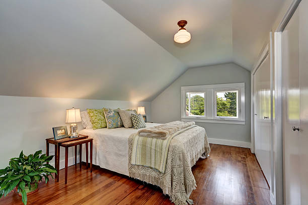 istock Attic bedroom interior with vaulted ceiling and hardwood floor. 599124246