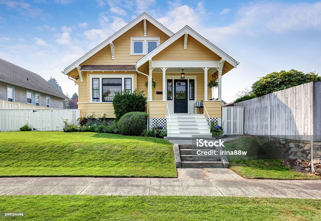 American craftsman home with yellow exterior paint. American craftsman home with yellow exterior paint and well kept front garden. Northwest, USA Outdoors Stock Photo