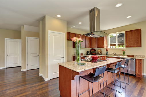 Traditional American kitchen featuring stainless steel appliances, range hood, an island and granite countertops. Northwest, USA
