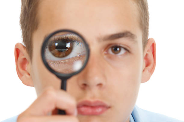 istock Caucasian guy looking through a magnifying glass isolated on white 599128412