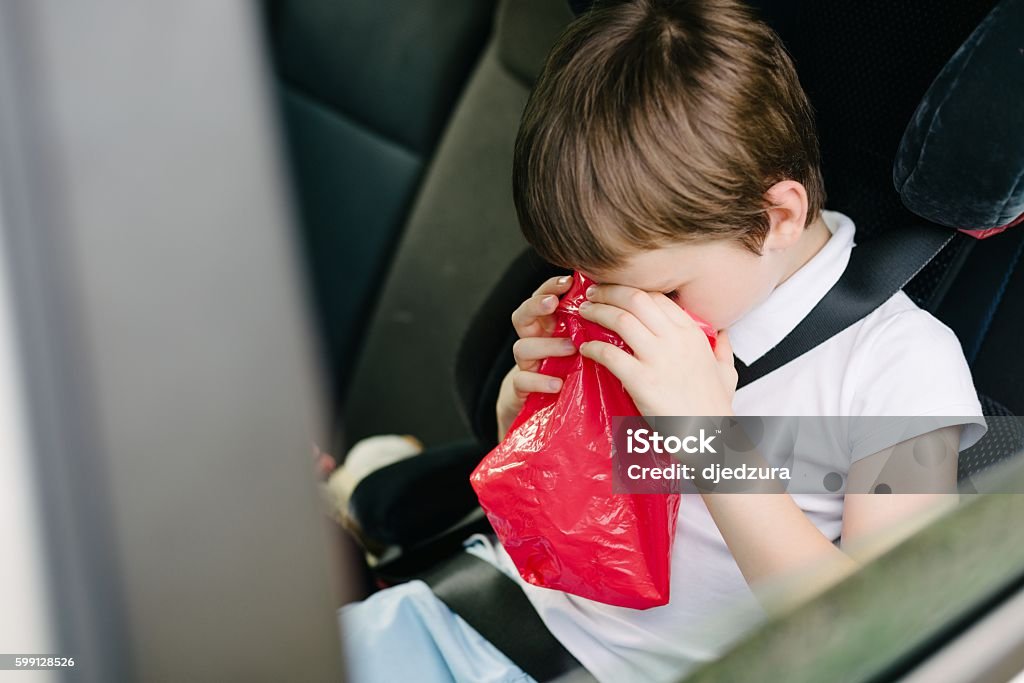 Seven years old child vomiting in car Seven years old child vomiting in car - suffers from motion sickness Boys Stock Photo
