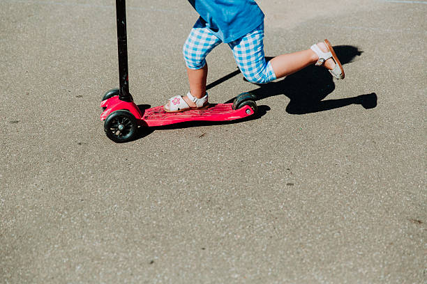 istock little girl riding scooter outdoors, active kids 599130168