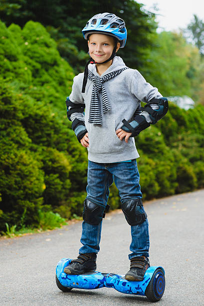 Happy boy riding on hoverboard or gyroscooter outdoor stock photo