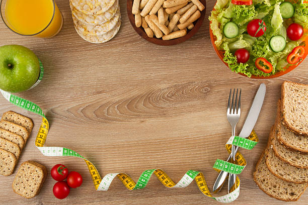 gesunde und diät-lebensmittel hintergrund - healthy eating fork tape measure still life stock-fotos und bilder
