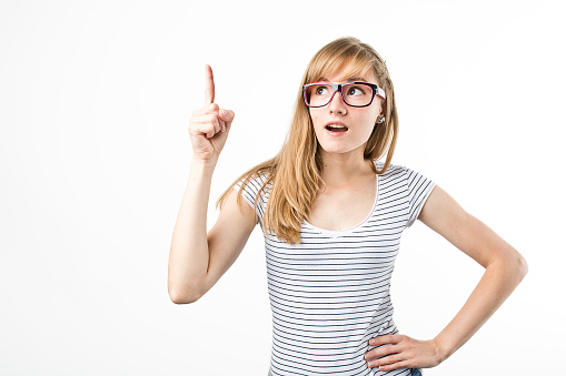 Beautiful young blond hair woman in glasses with finger point up. Hipster young and beautiful