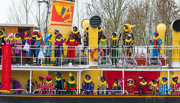 Sinterklaas arriving in The Netherlands Meppel, The Netherlands - November 14, 2015: The arrival of Sinterklaas in the city of Meppel on the steam boat Pakjesboot 12 coming from Spain. Sinterklaas is standing on the boatâs bow surrounded by his helpers the  Black Petes. The arrival in Meppel is the official arrival of Sinterklaas in The Netherlands for 2015 and is broadcasted on national television. Sinterklaas is a traditional Dutch holiday for children that is celebrated on the 5th of December. zwarte piet stock pictures, royalty-free photos & images