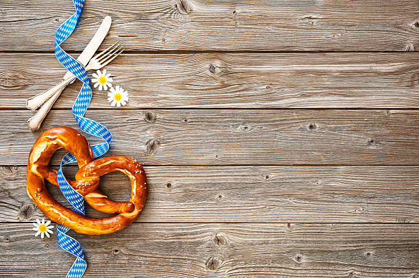 Background for Beer Fest Bavarian pretzel with ribbon and silverware on wooden board. Background for Beer Fest oktoberfest food stock pictures, royalty-free photos & images