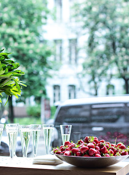 Dish with strawberries and champagne glasses on the table.