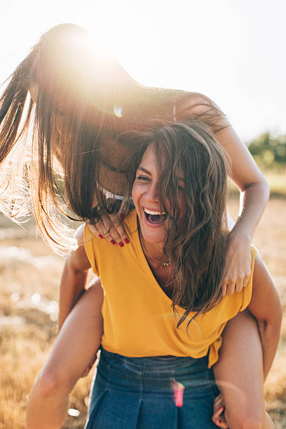 istock Smiling girlfriends having fun in piggyback ride 599141098