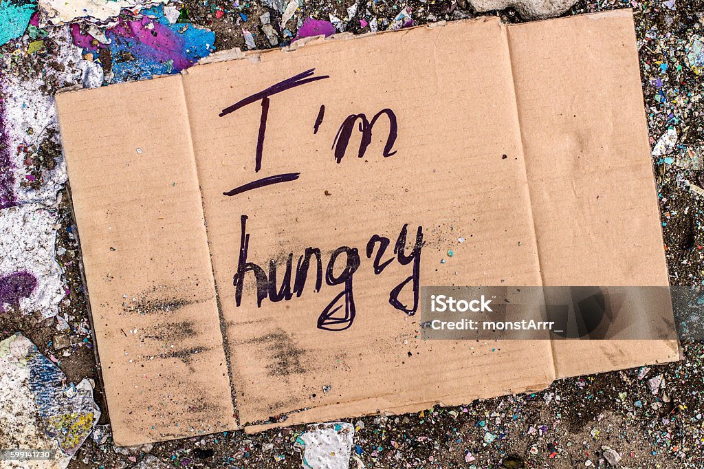 Sign of homeless man on cardboard Cardboard with request for food donation on the ground. Assistance Stock Photo