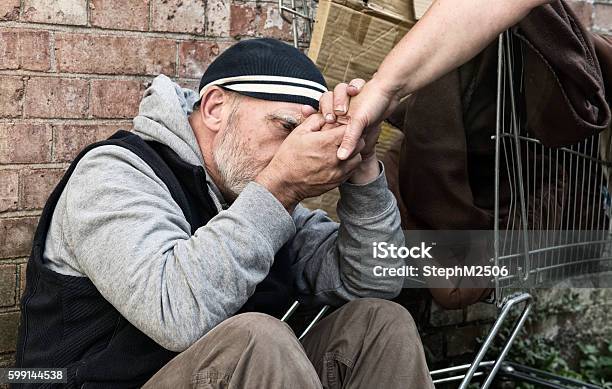 Homeless Man Taking A Womans Hand Stock Photo - Download Image Now - Assistance, Homelessness, Poverty