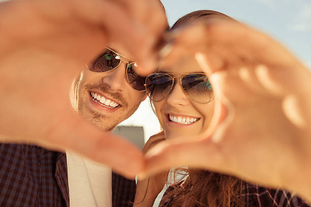 istock Cheerful romantic couple making heart gesture with hands 599144886
