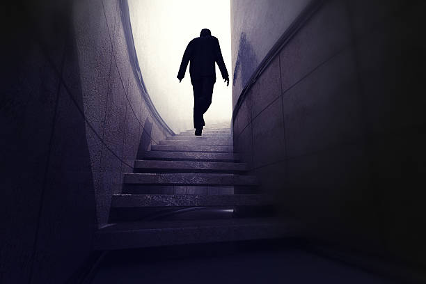 istock man climb up from darkness to reach progress 599145020