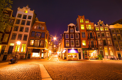 Night view streets of Amsterdam city. Dutch style buildings landscape in spring. Netherlands, Europe.