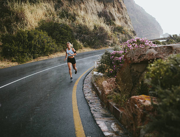 istock Fitness woman running outdoors on highway 599145908