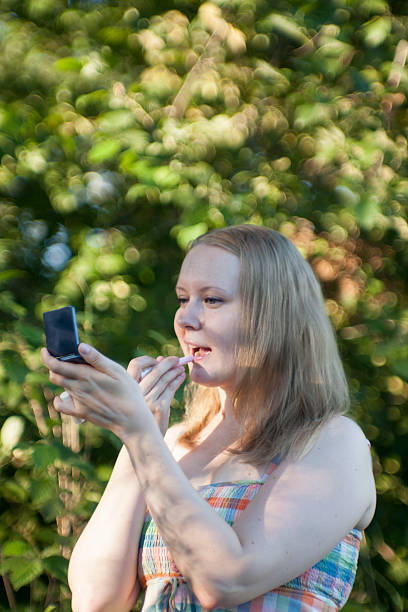 istock Young Woman Putting Lip-Balm On 599239428