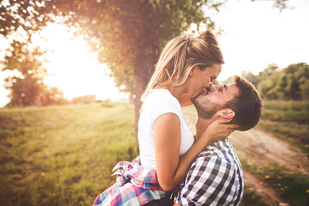 Hugging Photo of young couple enjoying in love kissing stock pictures, royalty-free photos & images