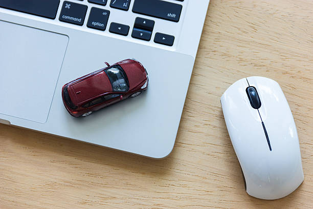 car model on notebook and mouse on wooden desk - car driver bildbanksfoton och bilder